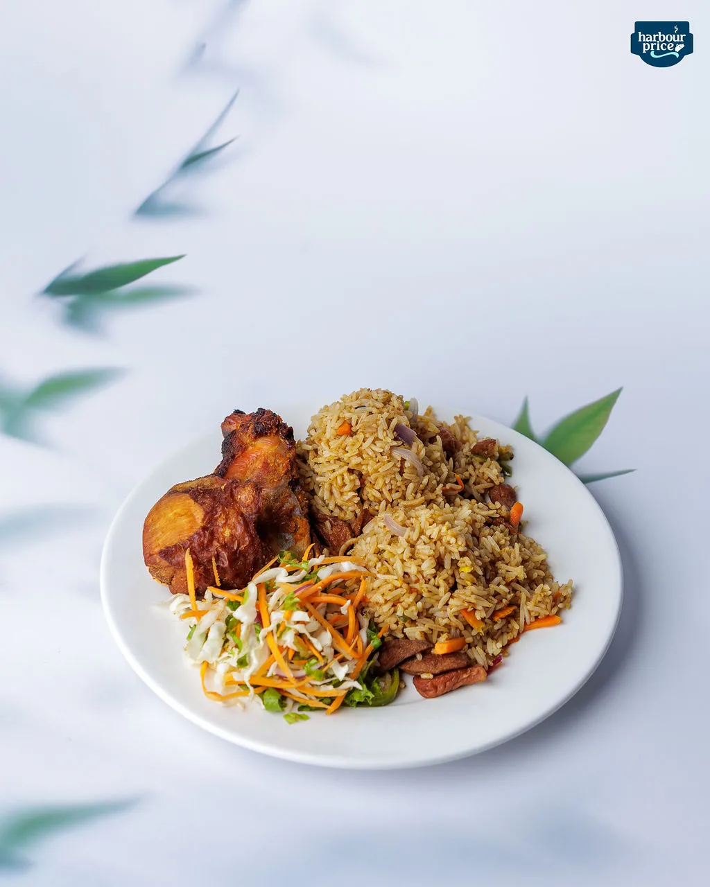 A plate of jollof and fried rice with fried chicken and fresh coleslaw