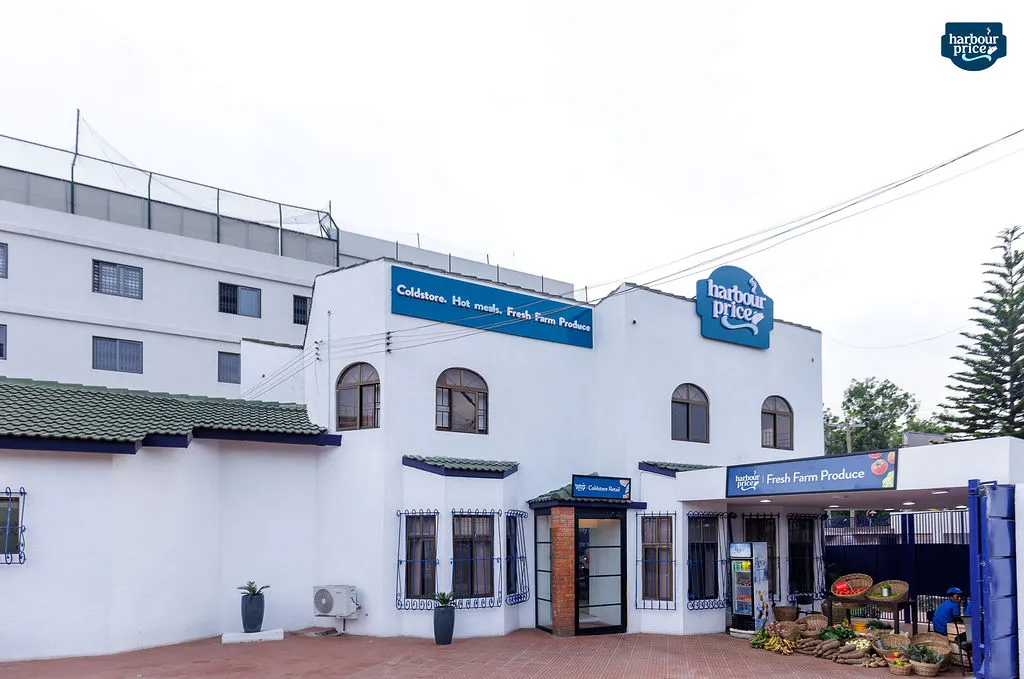 The white Harbour Price building with blue signage and fresh produce displayed out front